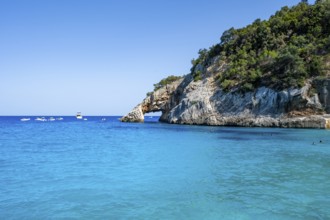Light blue clear sea on a dream beach on Cala GoloritzÃ©, picturesque rocky coast with rock tunnel,