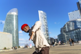 Young black man performing dynamic street dance in la defense, paris, striking a confident pose
