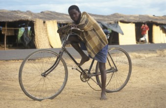 Boy with bicycle in front of a street market, Salima, Malawi, Africa, June 2000, vintage, retro,