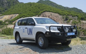 White UN SUV parked in front of a natural mountain landscape, Toyota of UNHCR, The UN Refugee