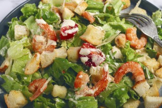 Caesar salad, with shrimp, on a marble background, top view, no people