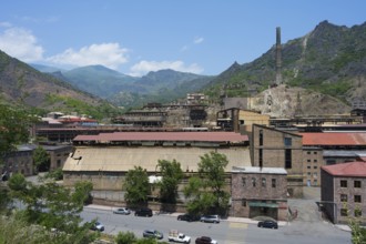 Old industrial complex with chimney in a mountainous area and blue sky, former copper smelter,