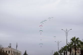 Damascus, Syria â€“ December 08, 2025: Paragliders display the Syrian flag during the first