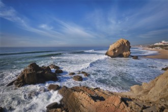 Penedo do Guincho, a large boulder rock arch at Praia da Santa Cruz, Portugal, with ocean waves and