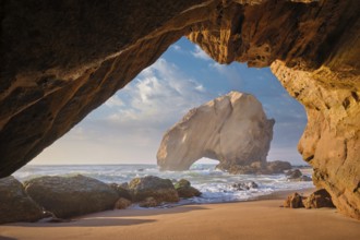 Penedo do Guincho, a large boulder rock arch at Praia da Santa Cruz, Portugal, with ocean waves and