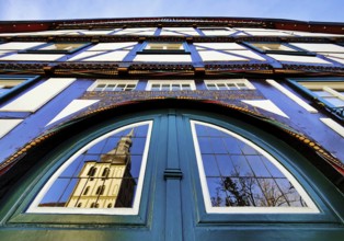 Door detail on the half-timbered house Altes brewhouse with the reflection of the church tower of