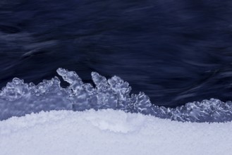 Ice formation formed by frost and freezing cold temperatures over running water of stream along
