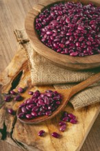 Red beans, laid out in a wooden bowl, on a chopping board, rustic style, covered with burlap, top