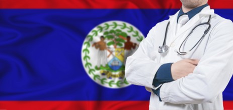 Belize healthcare concept. Male doctor on Belizean flag. Doctor with crossed arms on Belize flag