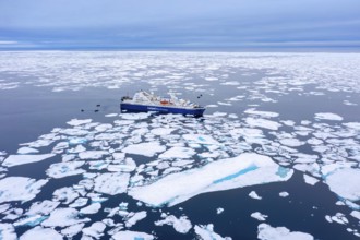 Aerial view over cruise ship Ocean Diamond from Iceland Pro Cruises sailing among drift ice / brash