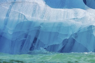 Blue ice pattern from erosion by sea water on base of melting iceberg in the Arctic Ocean at