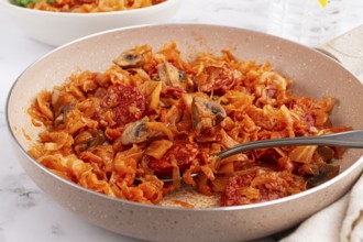 Bigos, Polish dish bigos, on the table, pan with stewed meat, with cabbage, chorizo sausages,