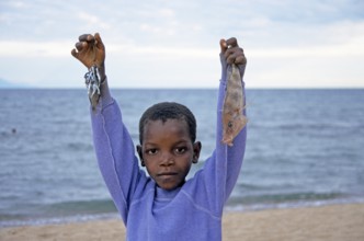 Little boy posing with caught fish for camera, Chitimba, Lake Malawi, Africa, July 2000, vintage,