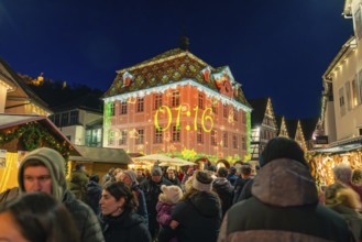 Illuminated building projection showing time at a well-visited Christmas market, Christmas market
