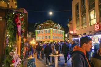 Building with festive light projection on a busy Christmas market, Christmas market 2025, Nagold,