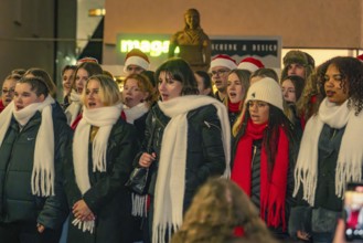 A choir sings outside, the singers wear warm clothes and atmospheric hats and scarves, Christmas