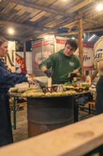Chefs at the stand prepare fresh pancakes at a Christmas market, Christmas market 2025, Nagold,