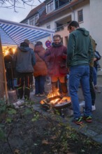 Small group of people around a warming campfire at a Christmas market on a cool evening, Aidlingen