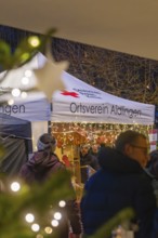 Visitors stroll past a tent that is lit up for Christmas, Aidlingen Christmas Market, Böblingen