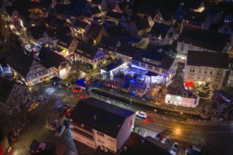 Aerial view of an illuminated village at night with decorated streets, Aidlingen Christmas market,