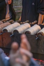 Fresh pastries are baked over an open fire at a market stand, Aidlingen Christmas Market, Böblingen