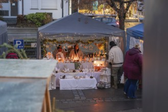 A festively decorated sales tent at a Christmas market with fairy lights and handmade items,