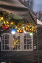 Festive Christmas decoration with lights and balls hanging on a tent, Aidlingen Christmas market,