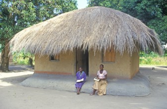 Two woman in front of a thatched house near Kande, Lake Malawi, Africa, July 2000, vintage, retro,