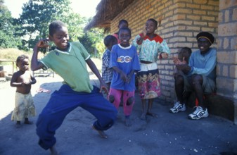 Local children dance happily to music in a village near Kande, Lake Malawi, Malawi, Africa, July