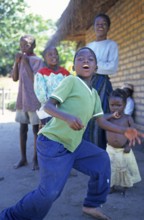 Local children dance happily to music in a village near Kande, Lake Malawi, Malawi, Africa, July