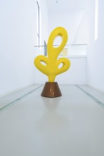 Yellow abstract sculpture in a modern, minimalistic gallery corridor, Open Horizons exhibition,