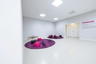 Modern room with purple and black seating and lettering on the wall, Open Horizons exhibition,