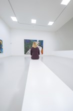 A woman sitting in a bright art gallery in front of an expressive painting, Open Horizons