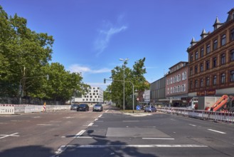Traffic light intersection, central island, fenced construction site, barrier, road construction,