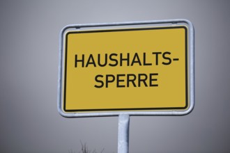 (Photo montage) Close-up of a town entrance sign with the inscription HOUSEHOLD LOCK