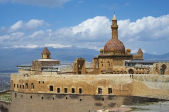 A historic building with dome and minaret, snow-capped mountains in the background, Ishak Pasha