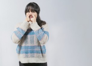 Asian woman covering nose because bad smells. Asian girl with a face from unpleasant odors. Concept