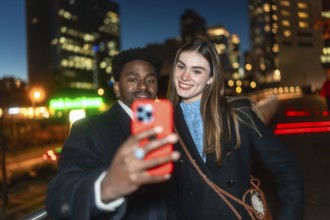 Diverse friends posing for a self portrait with a smartphone, smiling warmly as they enjoy a casual