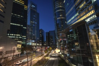 La defense skyline at blue hour, modern glass skyscrapers and illuminated streets reflecting city