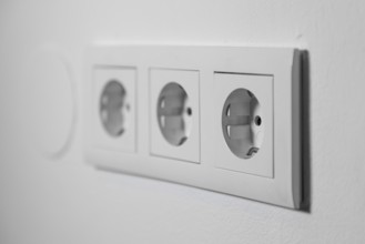 White triple outlet on a white wall