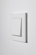 White light switch on a white wall, minimalistic design