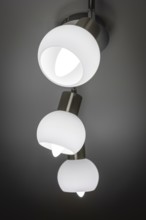 Modern ceiling lamp with three white, bowl-shaped lights