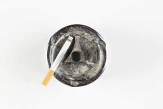 Used ashtray with cigarette, on white background