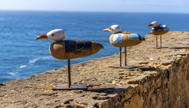 Wooden seagulls, art on the fortress at Farol de Nazare lighthouse, an annual meeting place in