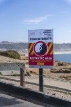Sign with a warning about the cliff edge, Farol de Nazare, Portugal