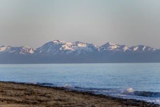 Anchor Point beach on Cook Inlet in the evening light, snowy mountain peaks of the Kenai Peninsula,