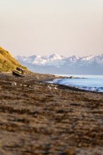 Boat on Anchor Point beach on Cook Inlet in the evening light, snowy mountain peaks, Anchor River
