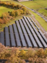 Large areas of installed solar panels surrounded by autumnal landscapes, construction of a PV