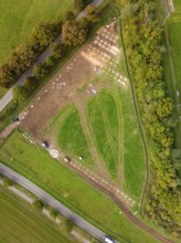 Aerial view of a green landscape with fences and roads surrounded by trees, construction of a PV