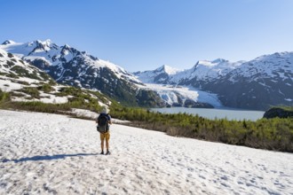 Hikers on a snowfield on the Portage Pass Trail, snowy mountains, Portage Glacier and Portage Lake,